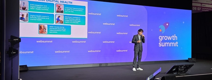 homem palestrando em palco de evento com painel com slide ao fundo