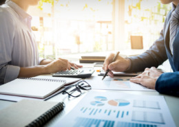 duas pessoas em sala de reunião com papeis na mesa