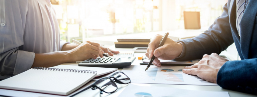 duas pessoas em sala de reunião com papeis na mesa