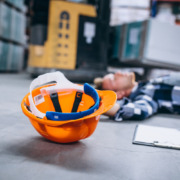 homem caído no chão com capacete de EPI ao lado