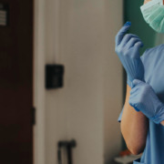 enfermeira de azul com máscara de proteção e luva descartável