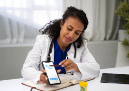 médica em consultório mostrando aplicativo em celular
