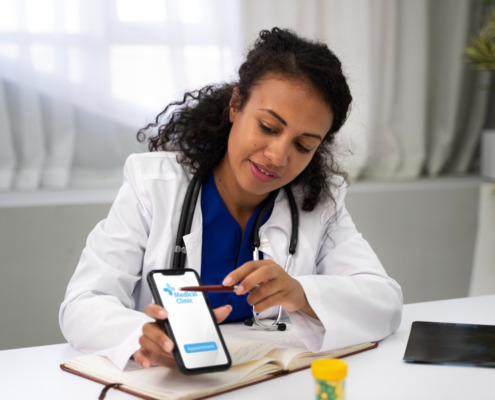 médica em consultório mostrando aplicativo em celular
