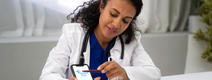 médica em consultório mostrando aplicativo em celular