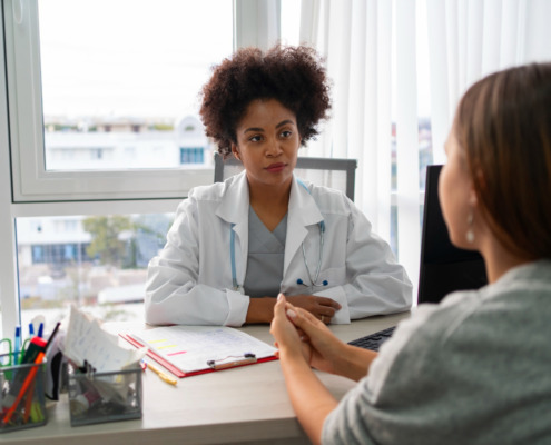 médica em consultório com conversando com paciente