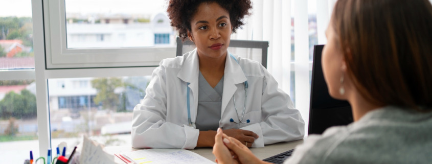 médica em consultório com conversando com paciente