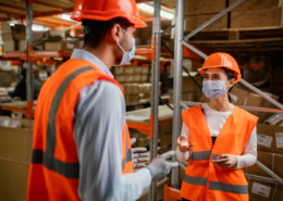 funcionários com EPIs em galpão de empresa