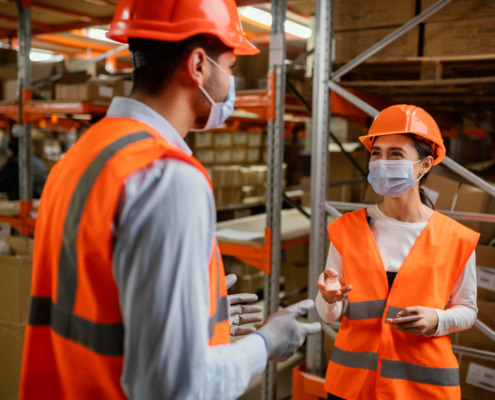 funcionários com EPIs em galpão de empresa