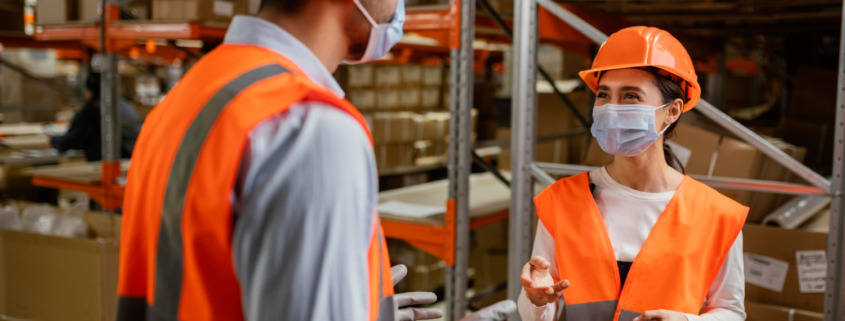 funcionários com EPIs em galpão de empresa
