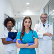 três médicos em pé em corredor de hospital