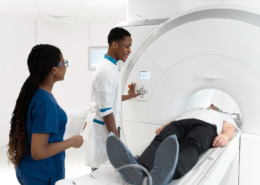 casal de enfermeiro auxilia paciente em exame de tomografia de imagem