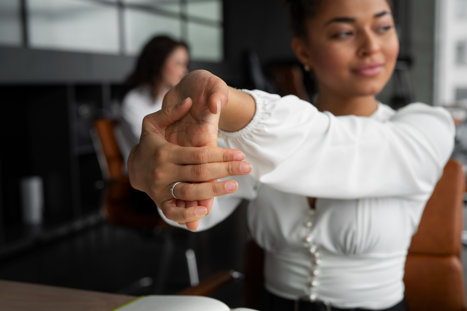 mulher no escritório alongando as palmas da mão