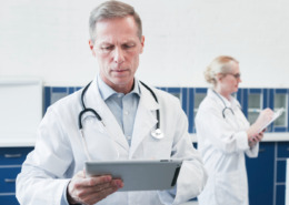 médico de jaleco branco olhando prancheta