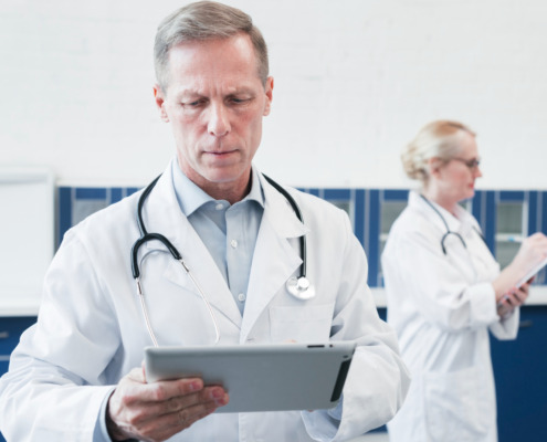 médico de jaleco branco olhando prancheta