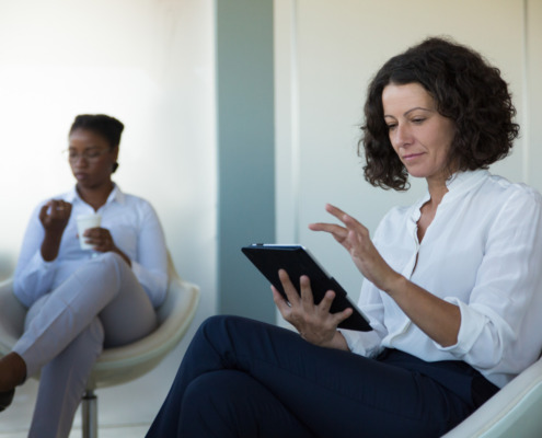 profissional de camisa branca com outra parceira na sala