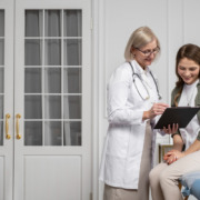 médica conversa com paciente em maca de clínica