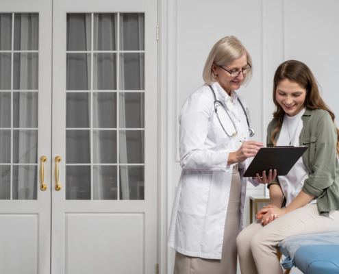 médica conversa com paciente em maca de clínica
