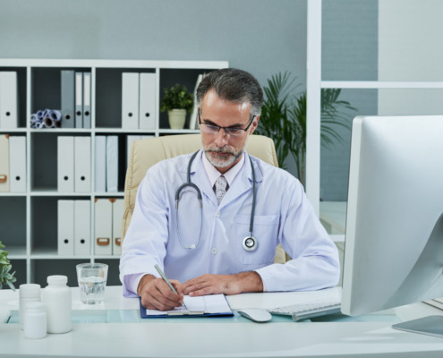 médico em consultório assinando documento