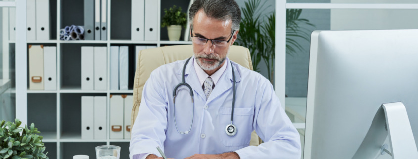 médico em consultório assinando documento