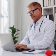 médico de jaleco branco em consultório