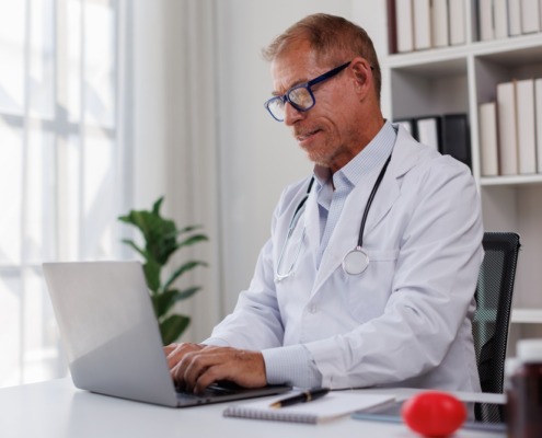 médico de jaleco branco em consultório