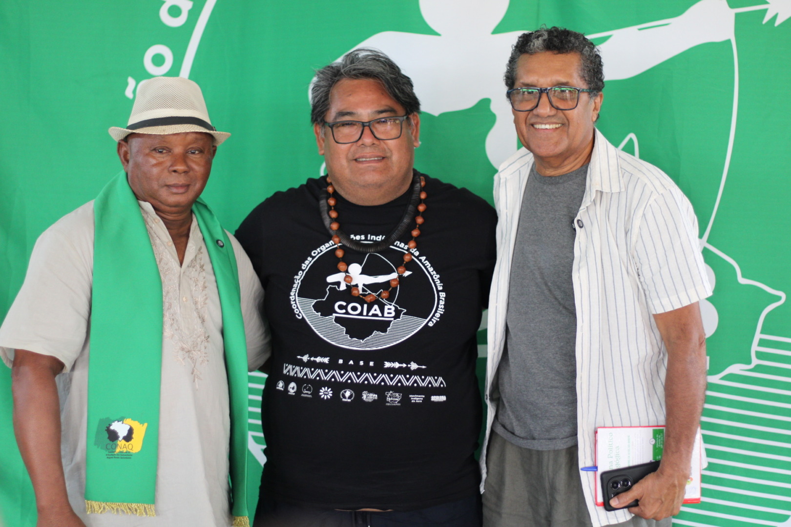 três homens abraçados pousando para foto e sorrindo