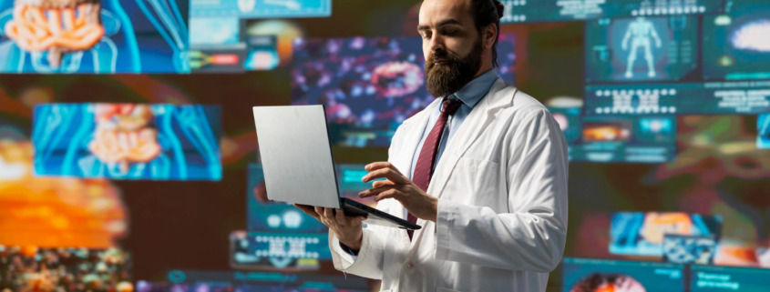 médico em pé na sala rodeado de telas com dados e gráficos digitais, simbolizando a tecnologia