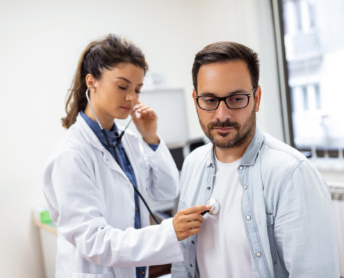 médica avaliando paciente em consultório