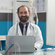 médico de jaleco branco em consultório