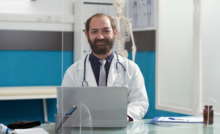 médico de jaleco branco em consultório