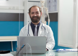 médico de jaleco branco em consultório