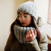 mulher com roupa de frio em área interna de casa