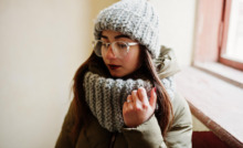 mulher com roupa de frio em área interna de casa