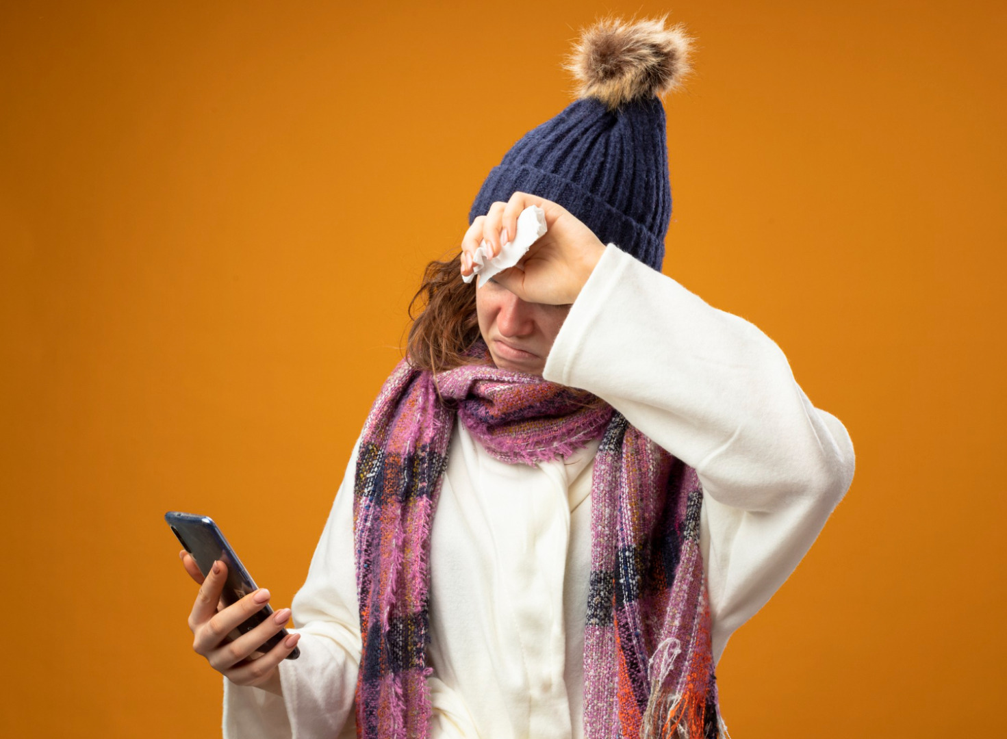 pessoa com roupa de inverno e mão no rosto com papel