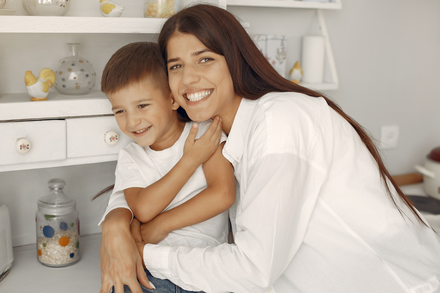 mãe abraçando filho e sorrindo em espaço residencial
