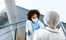 profissionais de saúde se cruzando em escada de área médica conversando