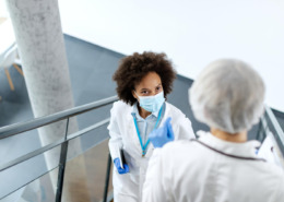 profissionais de saúde se cruzando em escada de área médica conversando