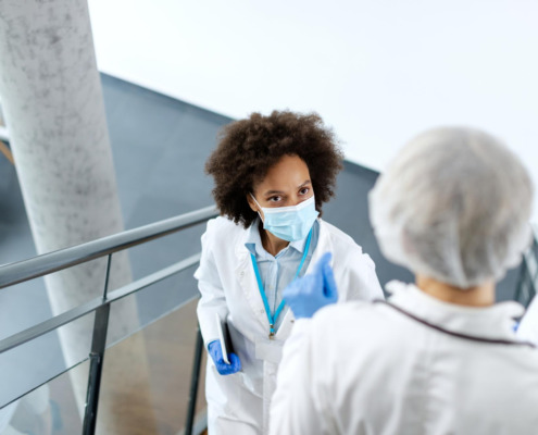 profissionais de saúde se cruzando em escada de área médica conversando