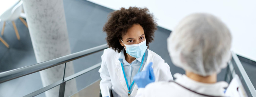 profissionais de saúde se cruzando em escada de área médica conversando