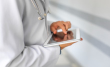 médico utilizando tablet com o dedo na tela