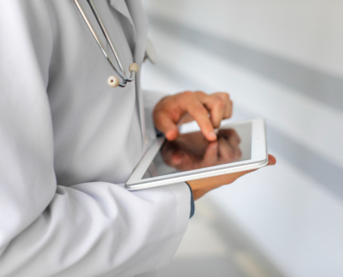 médico utilizando tablet com o dedo na tela