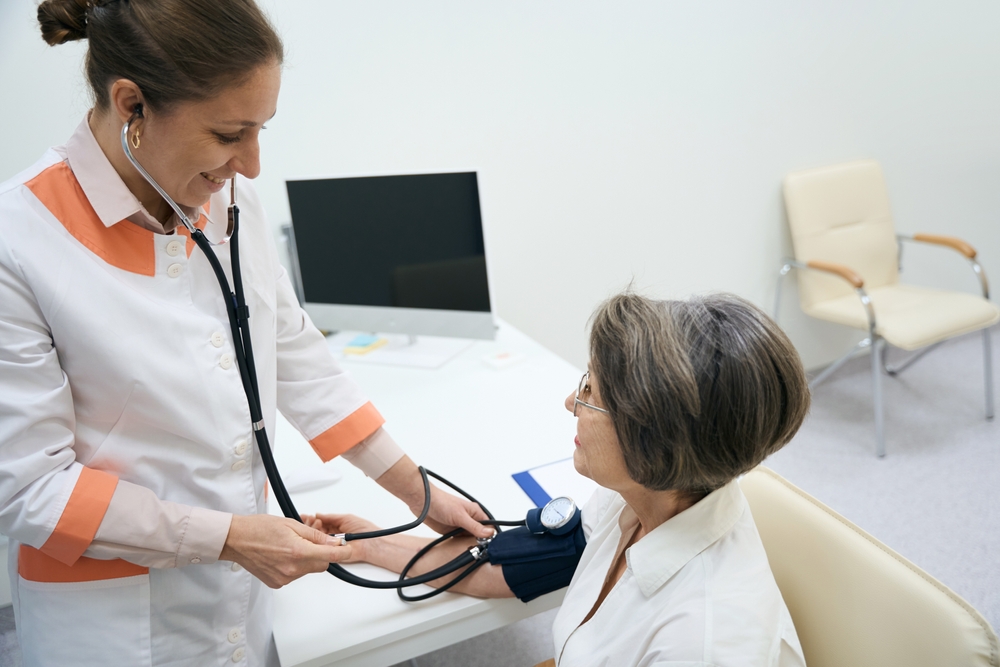 enfermeira medindo pressão arterial em paciente sentada