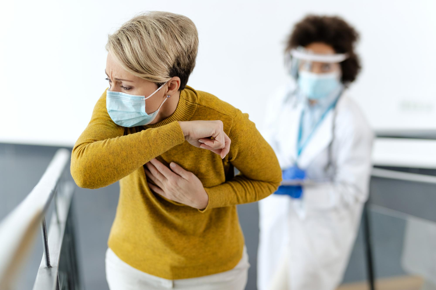 paciente utilizando máscara de proteção e sendo acompanhada por profissional da saúde simbolizando problemas respiratórios