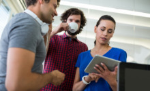 pessoas reunidas vendo as informações que uma delas compartilha no tablet