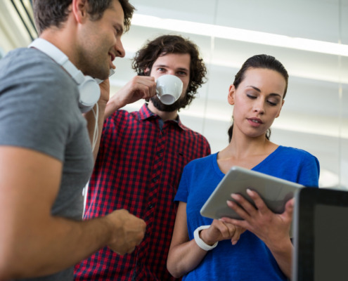 pessoas reunidas vendo as informações que uma delas compartilha no tablet