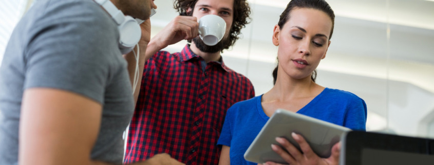 pessoas reunidas vendo as informações que uma delas compartilha no tablet