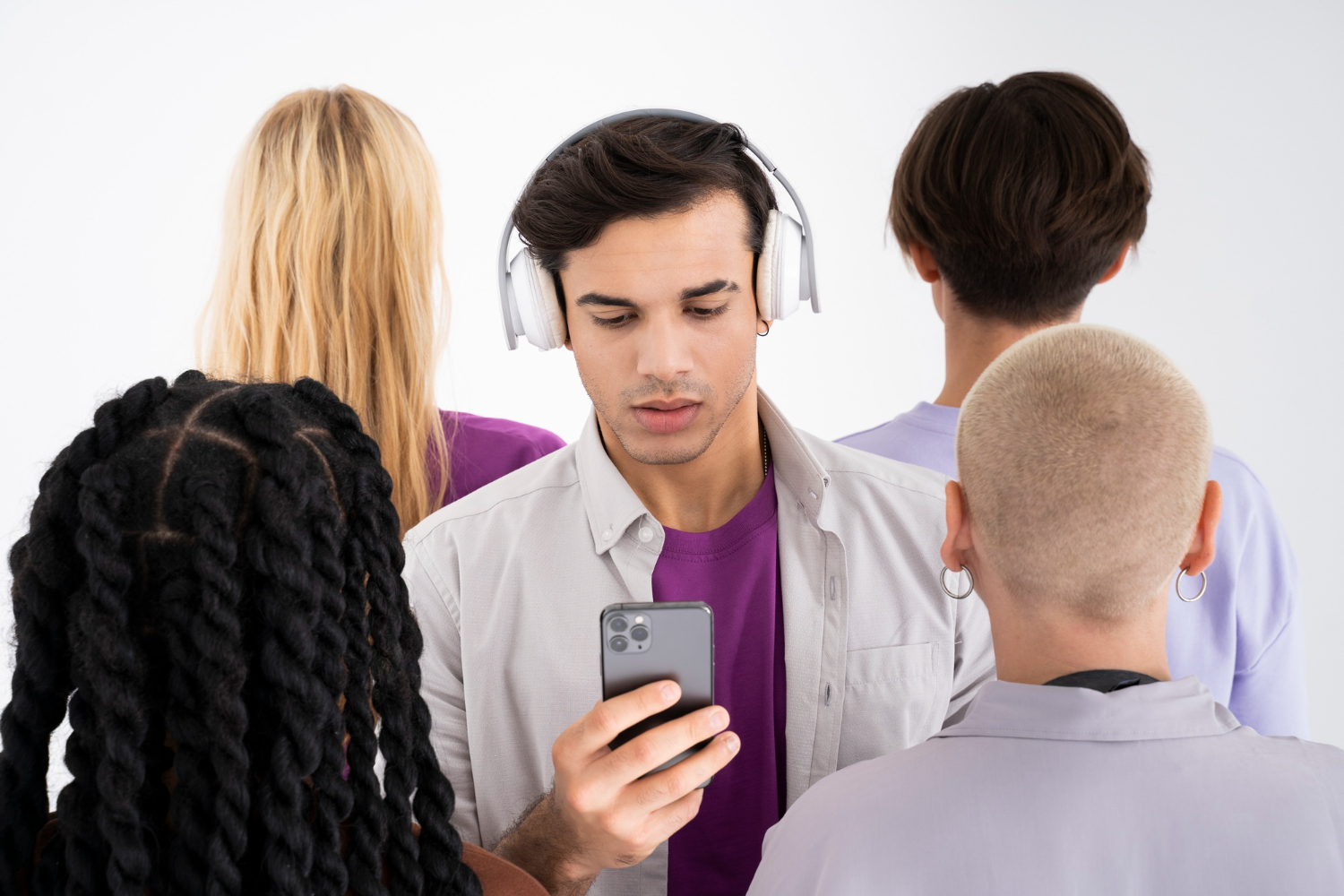 pessoas em ambiente fechado com uma delas utilizando celular