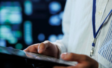médico utilizando tablet simbolizando atualização de conteúdo médico