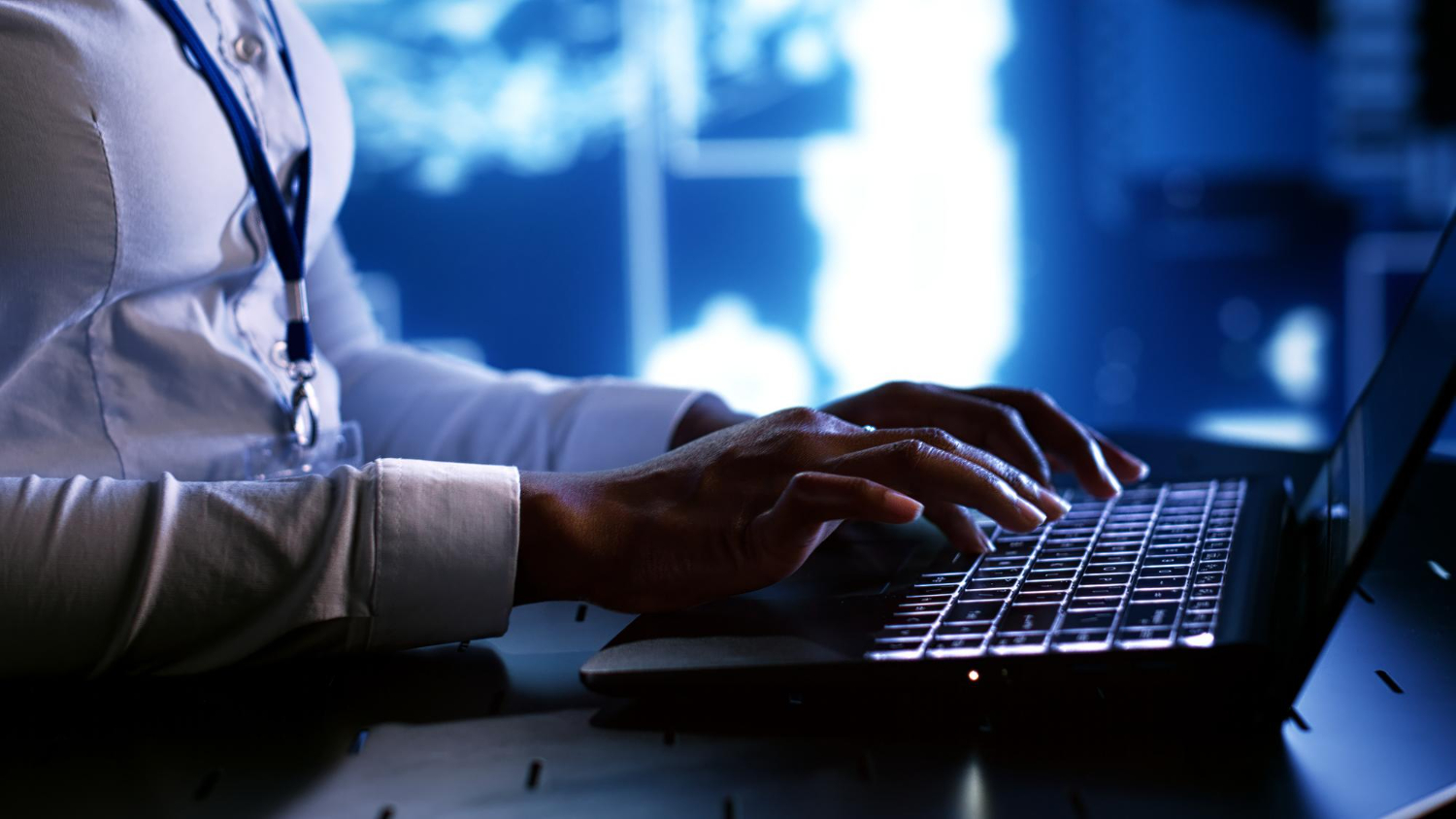 profissional utilizando notebook em ambiente corporativo