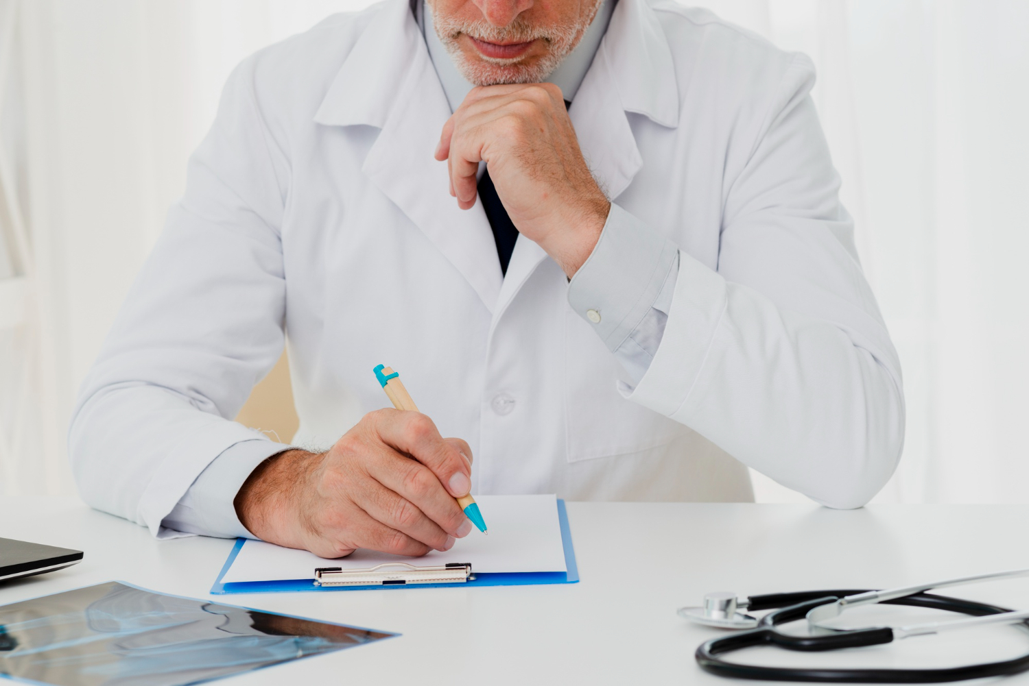 médico em consultório preenchendo prancheta